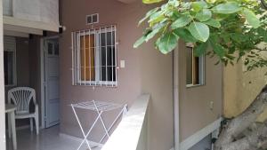 a building with a window and a table and a tree at Departamento en Centro de Mar de Ajo 1º piso in Mar de Ajó