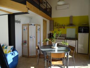 a kitchen with a table and chairs and a refrigerator at les cerisiers de stella in Blauvac