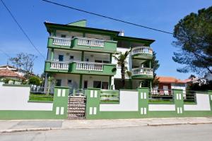 un edificio verde y blanco con balcones en B88 apartments - Vila Palma, en Sveti Filip i Jakov