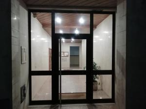 een glazen deur in een kamer met een spiegel bij Sailorman House in Aveiro