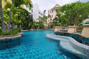 a pool at a resort with blue water and palm trees at Baan Karonburi Resort in Karon Beach