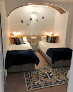 twee bedden in een kamer met vogels aan de muur bij Pico da Bica in Lissabon