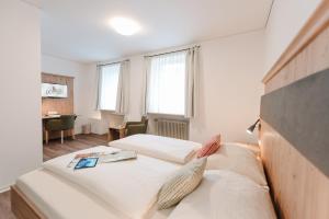 a bedroom with two beds and a desk in a room at Löwen Hotel & Restaurant in Marktbreit