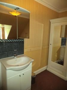 a bathroom with a white sink and a mirror at Menzies Guest House in Edinburgh