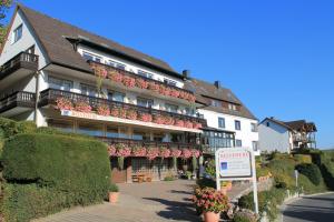 een hotel met een bord ervoor bij BELVEDERE Appart & Chalet - Ihr Zuhause auf Zeit am Edersee - Ihr Geschenk die GästeCard GrimmHeimat in Waldeck