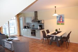 a kitchen and dining room with a table and chairs at Ostseeblick in Nienhagen