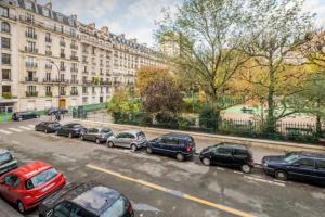 a parking lot with cars parked in front of a building at Appartement de charme entre Montmartre et Batignolles in Paris