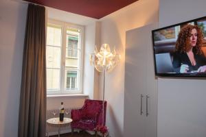 Habitación con TV, silla y mesa. en Boutique Hotel - Restaurant Orchidee, en Burgdorf