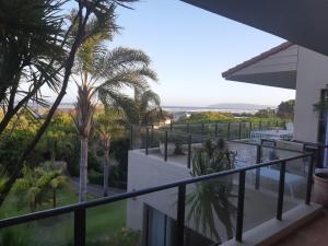 a view from the balcony of a house with palm trees at Tidal Retreat in Plettenberg Bay
