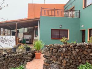 uma casa colorida com uma parede de pedra em frente em Casa Tanajara em El Pinar del Hierro