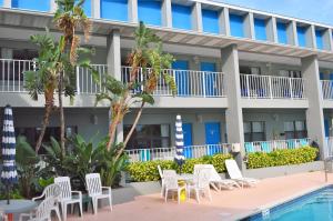 a resort with a pool and chairs and a building at Dockside Inn & Resort in Fort Pierce