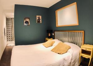タラスコンにあるAppartements entre Provence et Camargueの緑の壁のベッドルーム1室(白いベッド1台付)