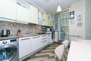 eine Küche mit weißen Schränken, einer Waschmaschine und einem Trockner in der Unterkunft Three-room apartments at the Polytechnic Institute in Kiew