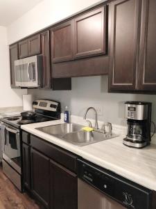 a kitchen with a sink and a stove at Cozy Condo in Central Raleigh in Raleigh