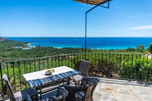 a table and chairs on a balcony with the ocean at Résidence Belvedere de Palombaggia in Porto-Vecchio