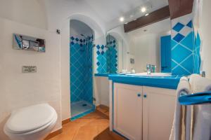 a blue and white bathroom with a toilet and a sink at Résidence Belvedere de Palombaggia in Porto-Vecchio