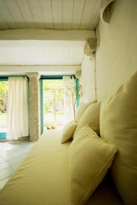 a bed with yellow pillows in a room with a window at Casa Sadde in Padru