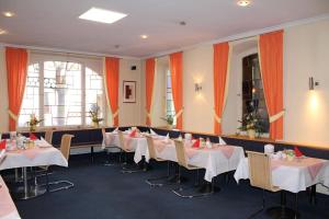 a dining room with white tables and chairs at Hotel Adlerhof in Tauberbischofsheim