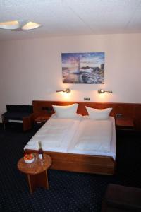 a bedroom with a large bed and a table at Hotel Adlerhof in Tauberbischofsheim