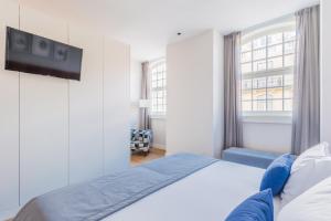 リスボンにあるAugusta Residence Apartmentsのベッドルーム1室(ベッド1台、壁にテレビ付)