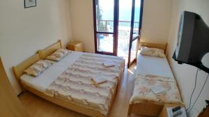Dormitorio pequeño con cama y TV en Guesthouse Obala, en Sutomore