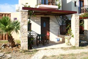 Casa con porche con mesa y sillas en Kavos Melissa Studios, en Agios Pavlos