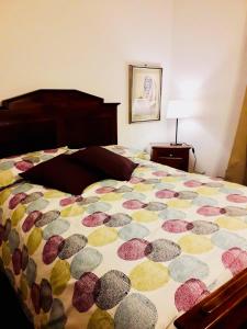 un letto con un piumone colorato in una camera da letto di B&B Mo Va Là a Budrio