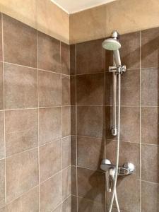 a shower with a shower head on a tiled wall at Apartament Familiar Av. Tarragona in Roses