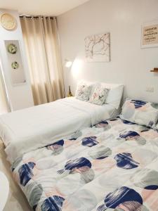 un grande letto in una camera con un letto di una piazza di Cloud 907 Cityscapes Condominium a Bacolod