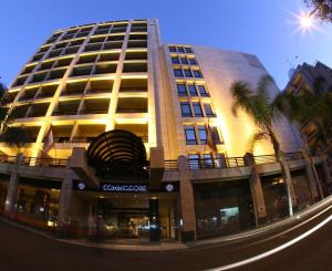 a large building with palm trees in front of it at Le Commodore Hotel in Beirut