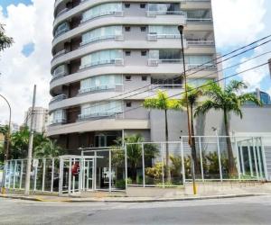 un edificio alto con palmeras delante en Be Paulista Apartamento 46, en São Paulo