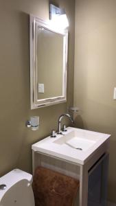 Un baño con lavabo, inodoro y espejo. en Duplex Rio Uruguay 161, en Monte Hermoso 43 fotos más