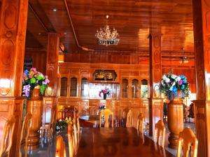 uma sala de jantar com uma mesa longa e flores em Morning Star Hotel em Banlung