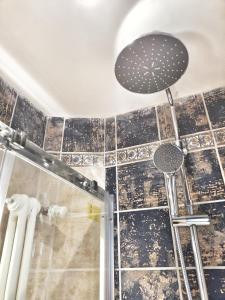 y baño con ducha y pared de azulejos negros. en Appartamento Luna 36 in centro a Firenze, en Florencia