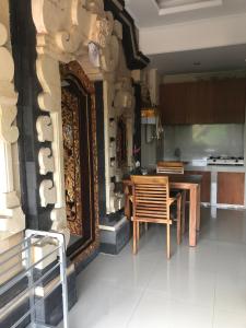 a kitchen with a table and chairs in a room at Oes House in Ubud