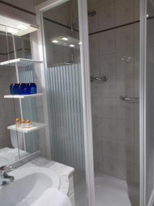 a bathroom with a shower, sink, and toilet at Eurohotel in Blankenberge