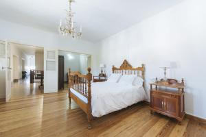 a bedroom with a large bed and a chandelier at Casa Rural La Higuera Mayor in Telde