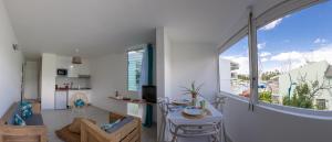 a living room with a table and a large window at Charmant 3 pièces à la marina Pointe du Bout aux 3 ilets in Les Trois-Îlets