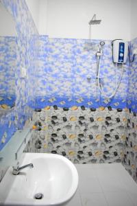a bathroom with a shower and a white sink at KAUSHIKA RESORT in Anuradhapura