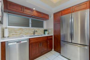 a kitchen with a refrigerator, stove, sink and microwave at Castle Waikiki Shore Beachfront Condominiums in Honolulu