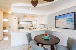 a kitchen and dining room with a table and chairs at Castle Waikiki Shore Beachfront Condominiums in Honolulu
