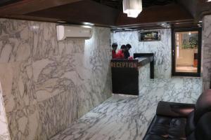 a lobby with a counter with a marble wall at Hotel Milan International in Mumbai