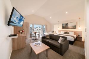 une chambre d'hôtel avec un lit et un canapé dans l'établissement Boathouse Resort Studios and Suites, à Blairgowrie