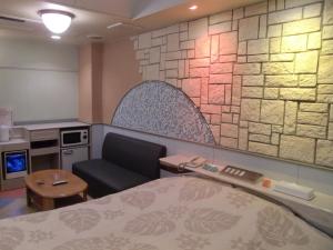 a hotel room with a bed and a couch at Hotel GOLF II Atsugi (Adult Only) in Atsugi