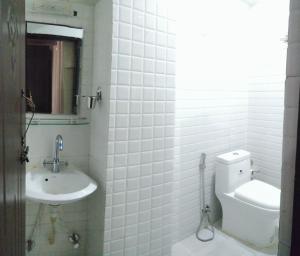 Baño blanco con aseo y lavamanos en Hotel Samrajya Pvt. Ltd., en Katmandú