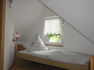 a small bedroom with a bed with a window at Ferienhaus Neubert in Wolkenstein