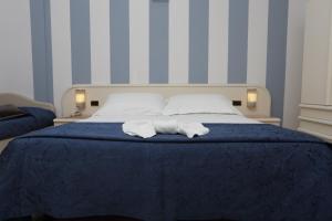 een slaapkamer met een bed met twee handdoeken erop bij Hotel Du Soleil in Rimini