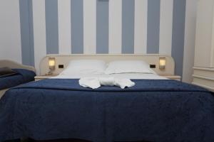 Hotel Du Soleil في ريميني: غرفة نوم عليها سرير وفوط