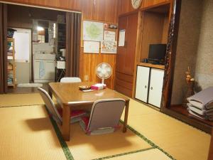 ein Esszimmer mit einem Holztisch und Stühlen in der Unterkunft Tirol in Yakushima