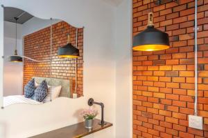 1 dormitorio con 2 luces y pared de ladrillo en BA​ Apartment​ Flow​Suvarnabhumi, en Bang Phli